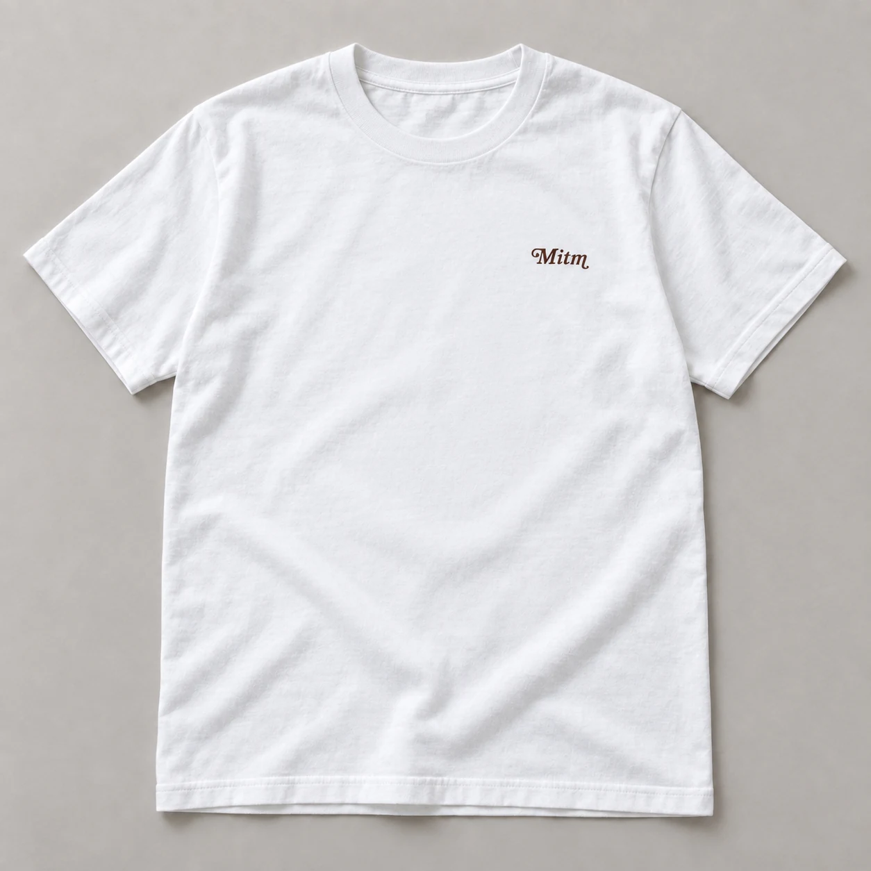 白いTシャツの前面。胸元に小さなMitmのロゴ